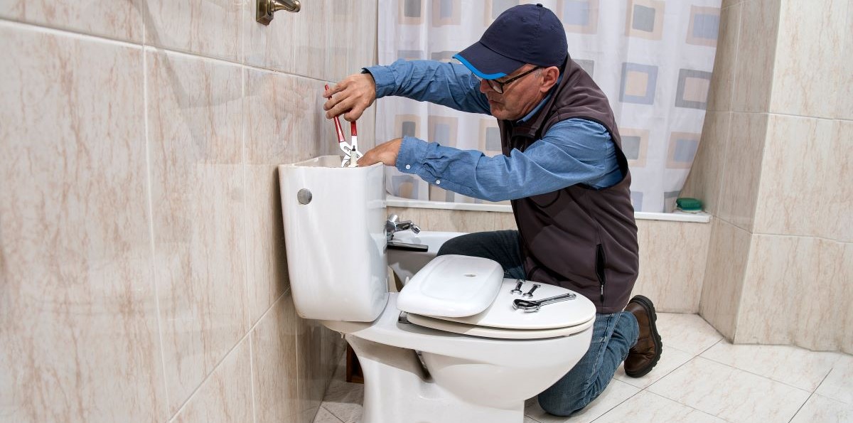 Plumber repairing toilet